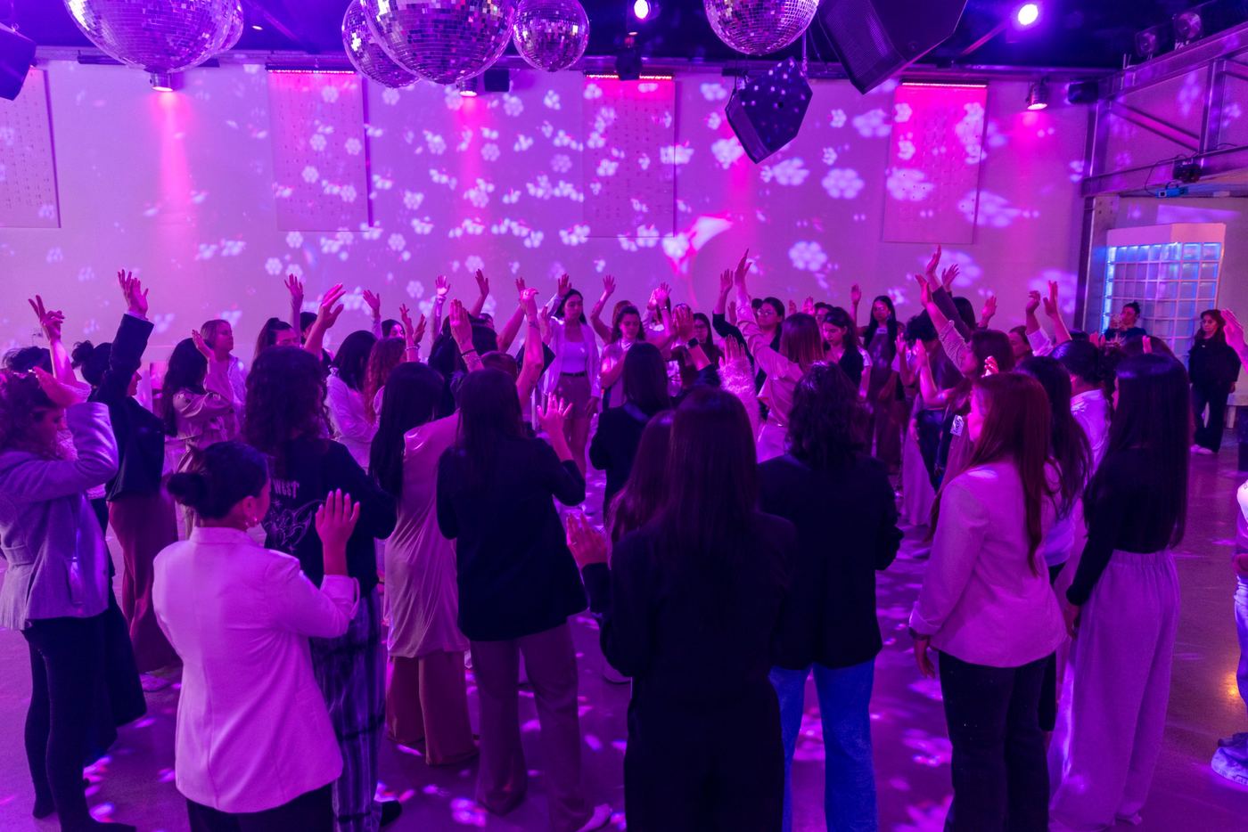 Ronda de mujeres con las manos en alto durante una dinámica