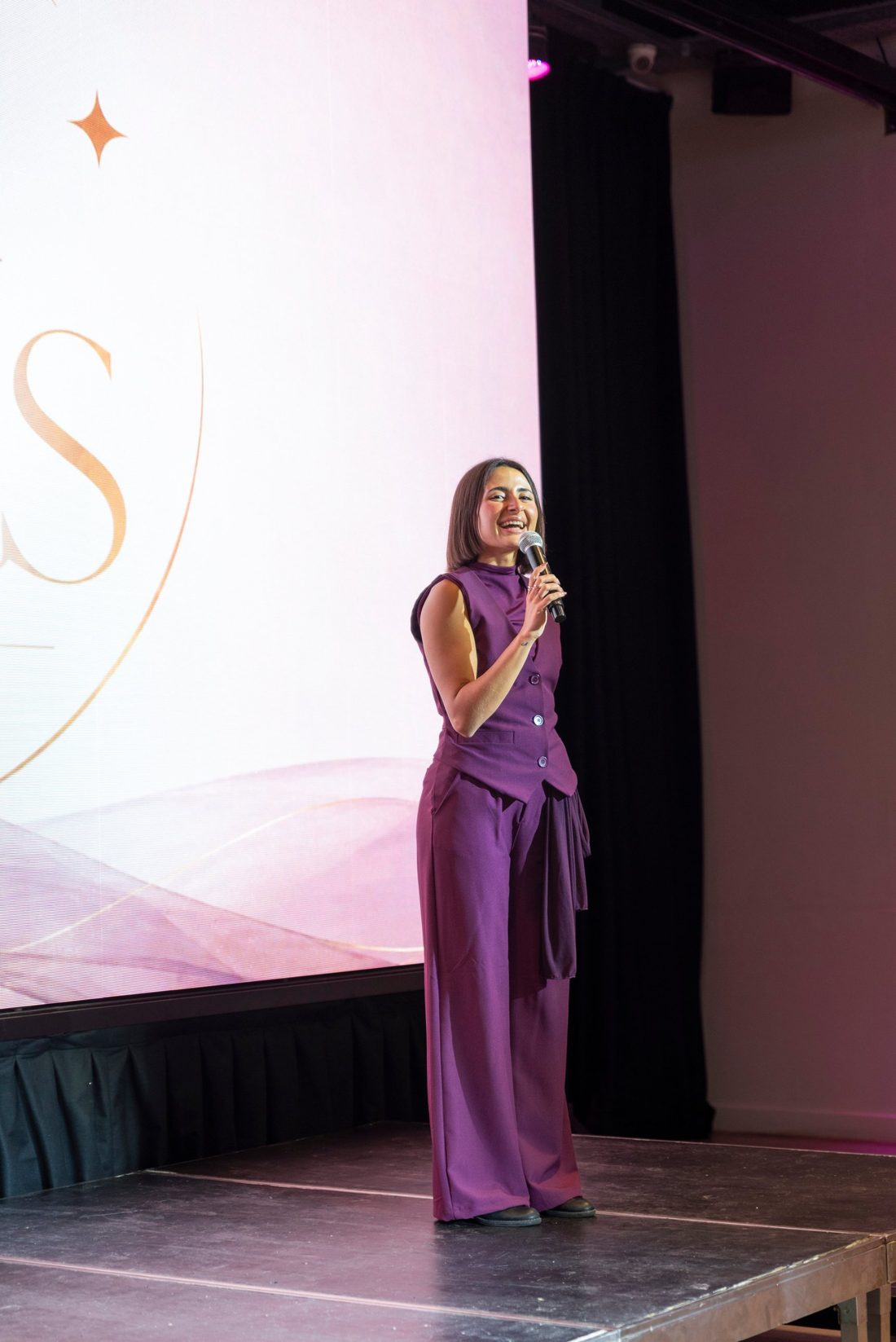 Valentina Parodi sonriendo en el escenario con el micrófono